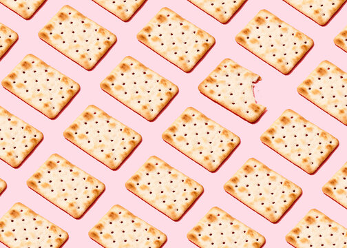Pattern of crackers flat laid against pink background