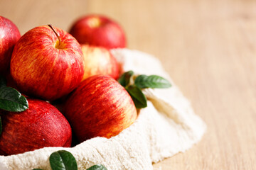 red apples in white plate on  wooden table.
