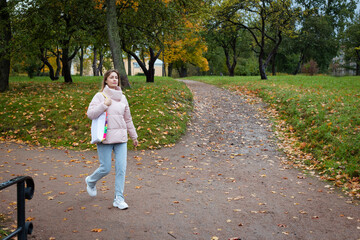eco girl walking in park with coffee cup ang bag