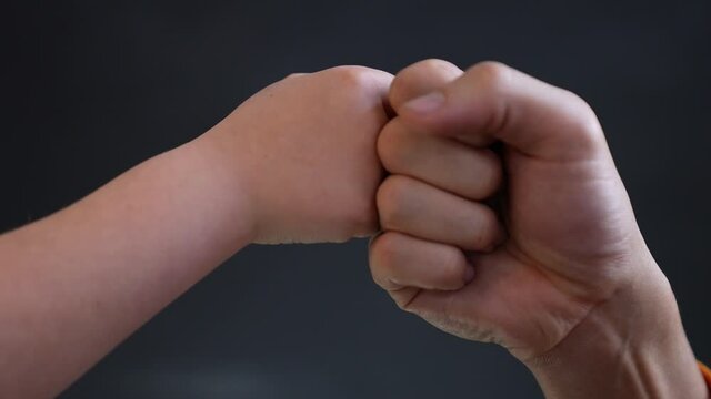 Father son fists together. Two fists together symbol of teamwork. Punching friendly greeting. Successful teamwork.Business contract greeting.Father and son fists together teamwork.Victory in business.