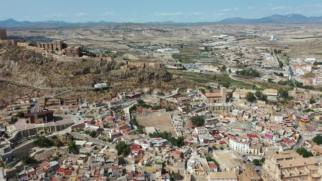 Aerial view of Spanish city of Lorca overlooking Collegiate church of St. Patrick and ancient castle on hilltop on sunny autumn day. High quality 4k footage