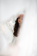 Reflection in the mirror of young pretty brunette girl with incredible makeup in white summer...