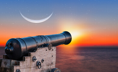 Ramadan Concept - Ramadan kareem cannon with crescent moon at amazing sunset
