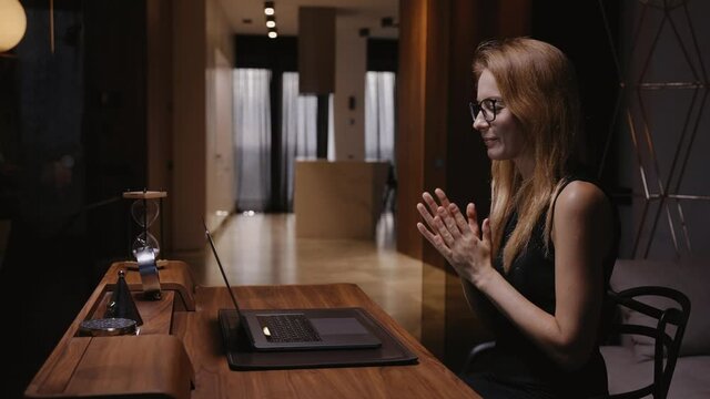 A woman in her home office sits at a table, stretches her hands and starts typing, conducts business correspondence, answers e-mail, fills out a questionnaire. Remote work. High quality 4k footage