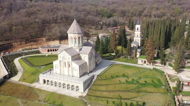 View from drone of architectural complex of Bodbe Monastery with Church of St. Nino on hill slope near Georgian town of Sighnaghi on sunny spring day