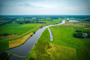 Drone view of the winding river Vecht, green grass, blue water, yellow buoys in the water. Vechtdal, Dalfsen the Netherlands