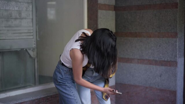 Angry Caucasian teen girl showing smartphone to classmate pushing head talking. Aggressive teenager fighting bullying stressed girl outdoors. Social media and adolescence concept