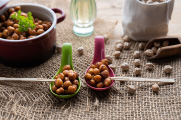 Vegan grilled chickpeas. Homemade vegan chickpeas, Crispy roasted organic chickpeas . Served as a snack in a bowl, on a wooden table top.