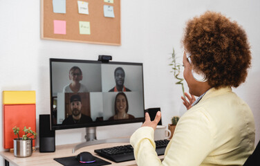 African woman doing video call meeting with co-workers from home - Lifestyle and technology concept - Focus on head