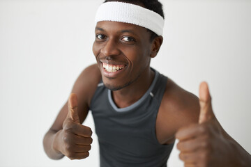 Close-up view of handsome, slim, sporty African American athlete with cute toothy smile in fitness...