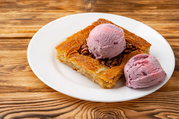 Turkish dessert kunefe served with ice cream on wooden background