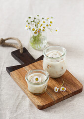 Traditional homemade goose lard with onion in glass jar and edible daisy flowers. Selective focus.