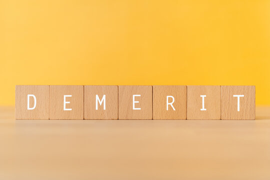 「DEMERIT」と書かれた積み木