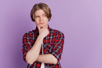 Portrait of doubtful creative smart guy fingers chin look blank space on purple background