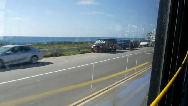 View from bus window, pacific coast highway 1, freeway 101 historic route, California USA. Road trip in public passenger transport. Journey along summer ocean or sea near Los Angeles. Yellow cord.