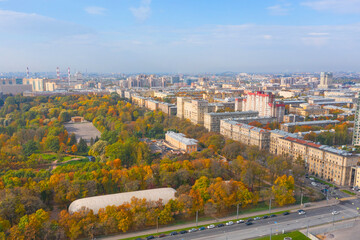 City autumn park among urban buildings, aerial view.