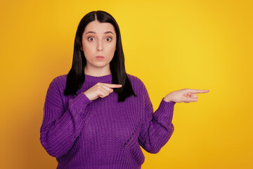 Portrait of young girl indicate fingers empty space advertisement promo suggest isolated over yellow color background