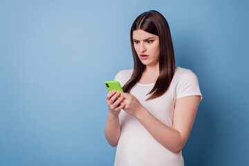 Portrait of speechless shocked lady hold phone look screen read post on blue background