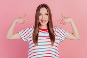 Portrait of crazy funny positive charming lady direct fingers herself on pink background