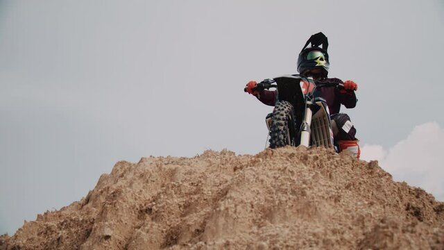 Motocross rider on his bike ready to race in dirt track, sport extreme and travel adventure concept.
