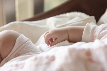 Obraz na płótnie Canvas Baby's tiny hand in the morning. Asian girl