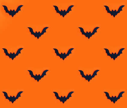 Seamless pattern black silhouette of a bat on orange.
