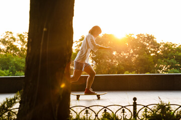 Happy young asian woman riding on a skateboard
