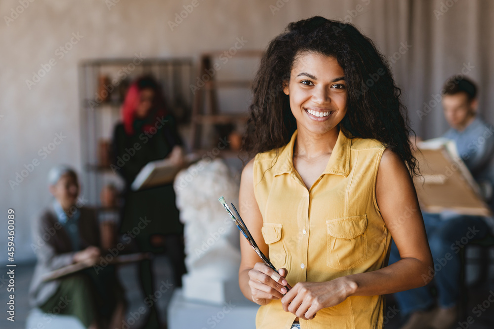 Wall mural young student woman smiling at camera during class in art school