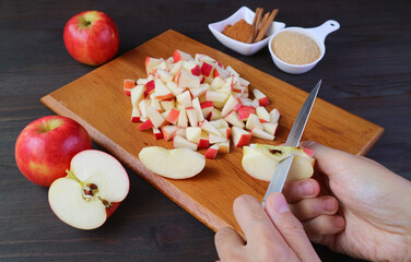 Man's hand cutting fresh apples with knife for making apple compote