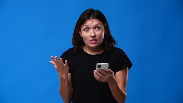 the girl scrolled the tape in the phone and she was very upset, the background is blue and the girl is dressed in black