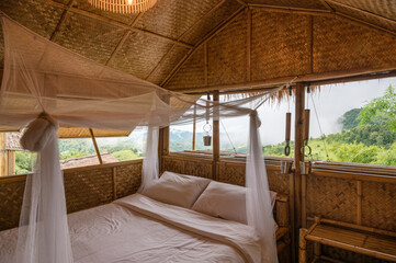 Inside the bedroom that made of wooden thatched with mosquito net among the mountain