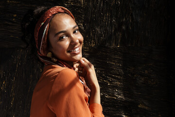 Young hispanic woman in headscarf smiling at camera