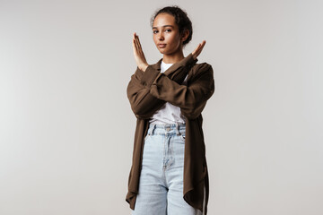 Young hispanic woman showing stop gesture at camera