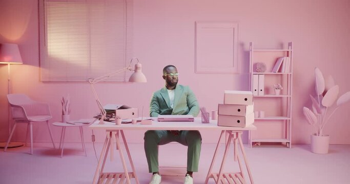 African tired exhausted angry man working hard in pink pastel room studio monocolor creative office with monochrome design. Using close laptop lose job bad news mail alone in green elegant suit no