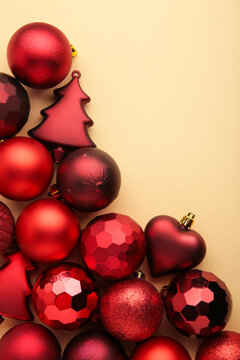 Red christmas baubles on beige background. New Year composition. Vertical photo