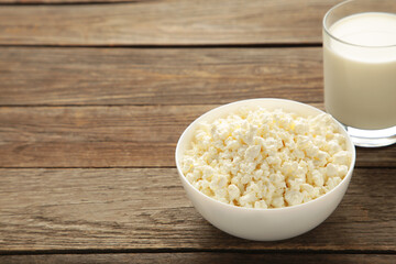 Cottage cheese and milk for breakfast in bowl on grey background.