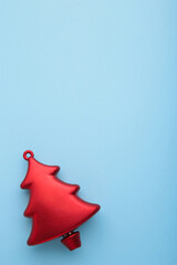 Christmas toy pine tree on blue background. Vertical photo