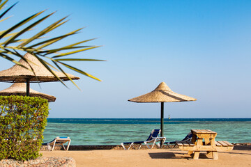 View of the beach with umbrellas and palm trees, the red sea, Hurghada, Egypt