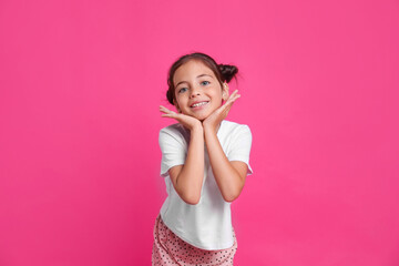 Obraz na płótnie Canvas Cute girl in pajamas on pink background