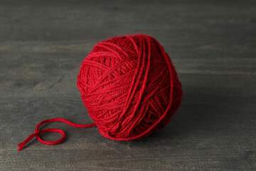 Red yarn ball on gray wooden table