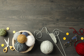 Concept of knitting with yarn balls on gray wooden table
