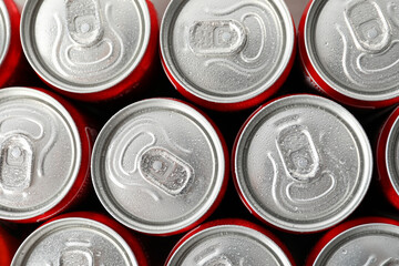 Cans with soda all over background, close up