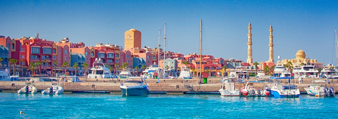HURGHADA, EGYPT - September 22, 2021 : Marina with tourist boats on Red Sea in sunny day, view from the sea. - obrazy, fototapety, plakaty
