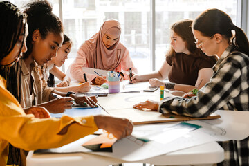 Multiracial young feminist women making posters during meeting