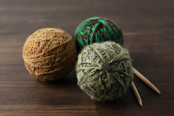 Yarn balls and knitting needles on wooden background