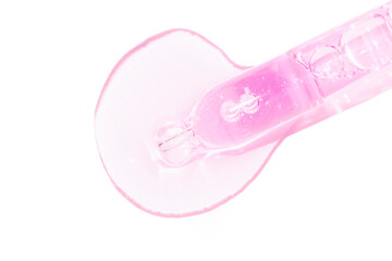 close up of a pipette dropper with pouring face serum on a white background