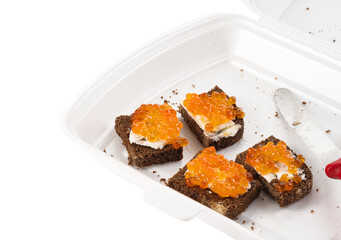 Sandwich with red salmon caviar with black bread in a plastic container. The concept of a healthy delicacy, seafood appetizer.