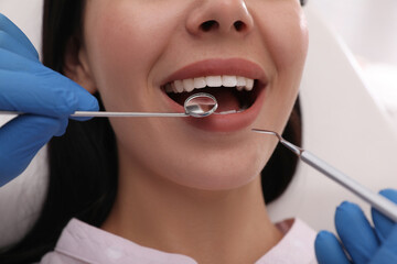 Dentist examining young woman's teeth, closeup view