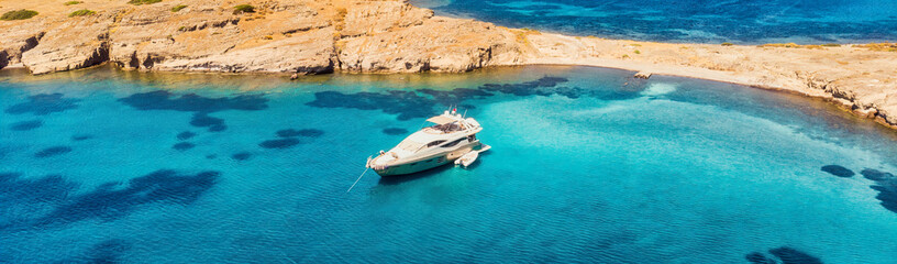 Fototapeta na wymiar View from above, stunning aerial view of a bay with boat, luxury yacht sailing on a turquoise, clear water.