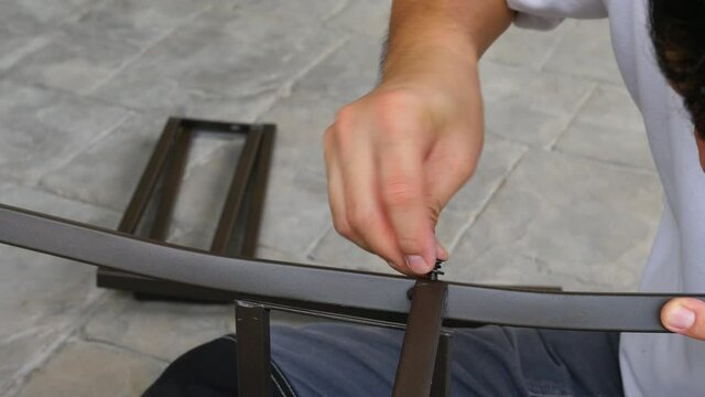 Man doing DIY assembly steel chair frame furniture interia decoration 